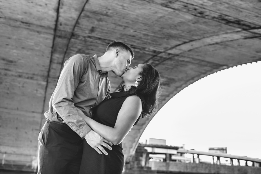 A man kisses his bride to be under 30th street bridge in Philadelphia.